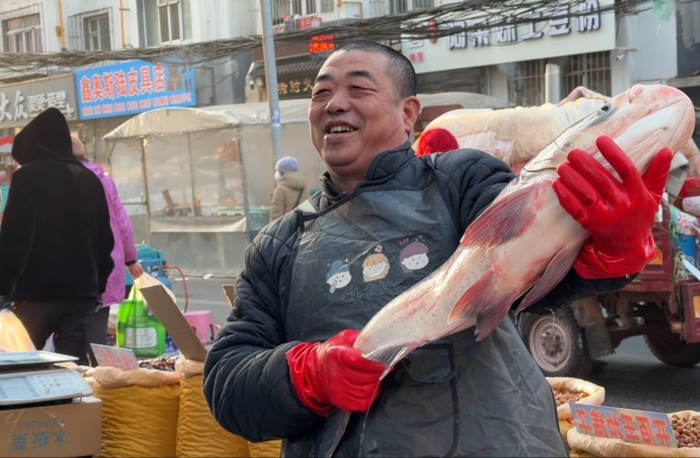 摊主在吉林省四平市公园北街早市卖鱼。新华社记者唐铭泽 摄