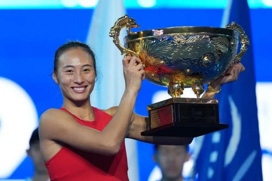 10月11日,郑钦文在2026中国网球公开赛女子单打决赛颁奖仪式上捧起冠军奖杯。图源:新华社