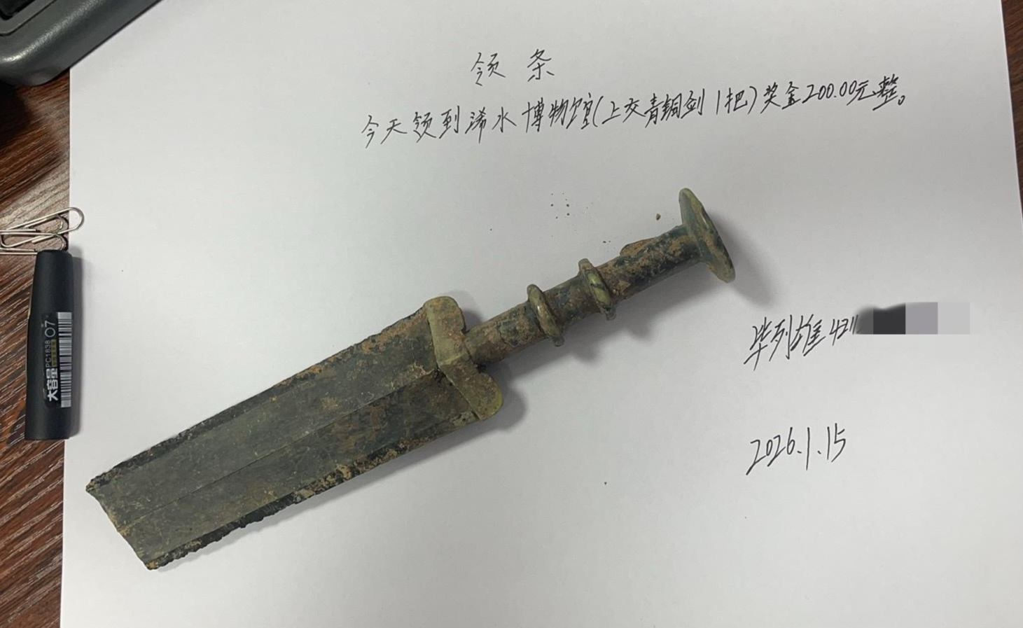 ▲毕列雄和他捡到的疑似古剑 受访者供图