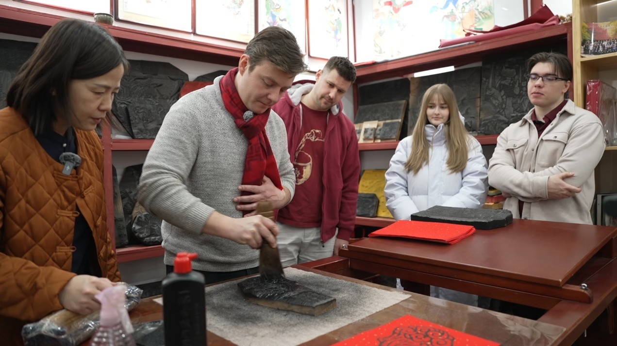 帝汉尼(左二)给匈牙利老乡们演示怎么拓年画