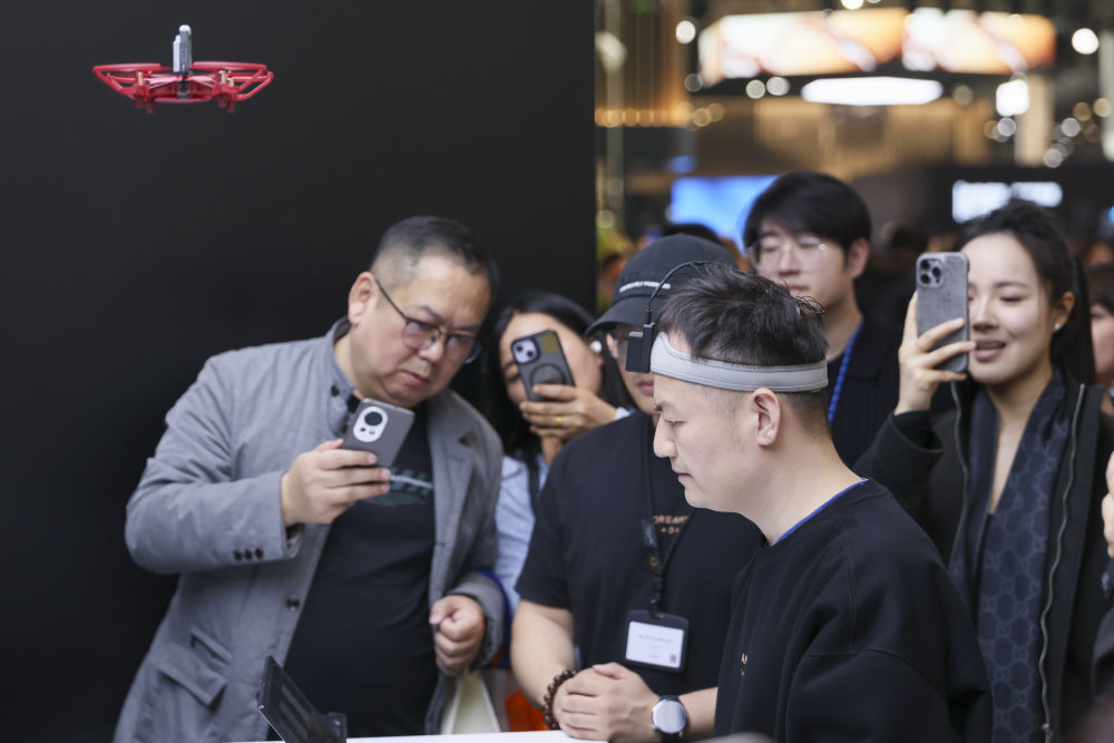 3月12日，在上海新国际博览中心追觅科技展位脑机接口展台，工作人员演示通过脑电波操作无人机。新华社记者王翔 摄