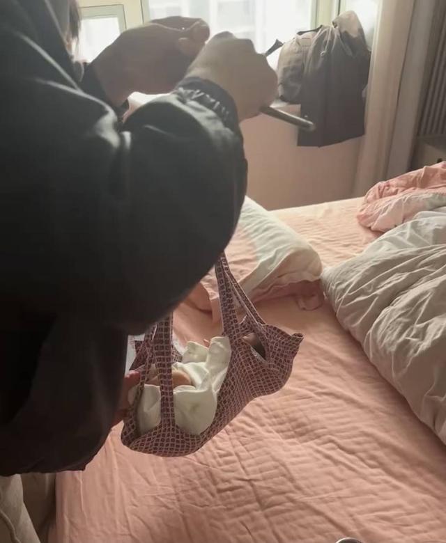 工作人员用老式杆秤为婴儿称重(视频截图)