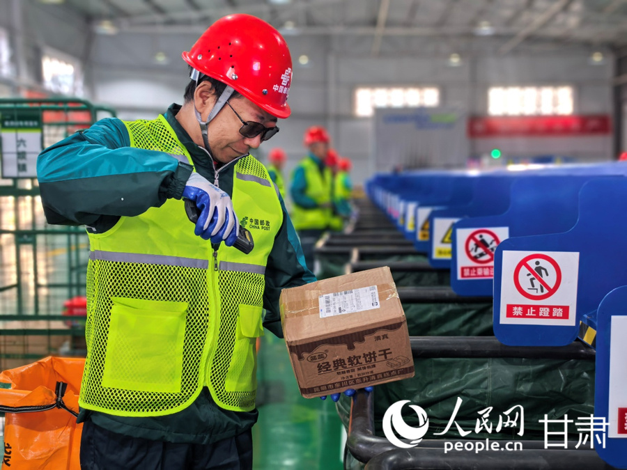 永昌县寄递物流共配中心,邮政分拣员梁玉顺正在查验和分拣快递包裹。人民网记者 高翔摄