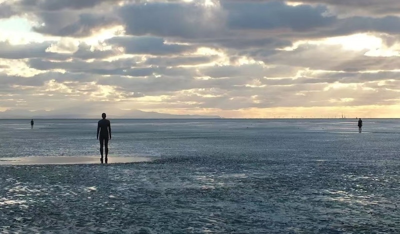 英国雕塑家安东尼·葛姆雷在利物浦海边创作的作品《别处》
