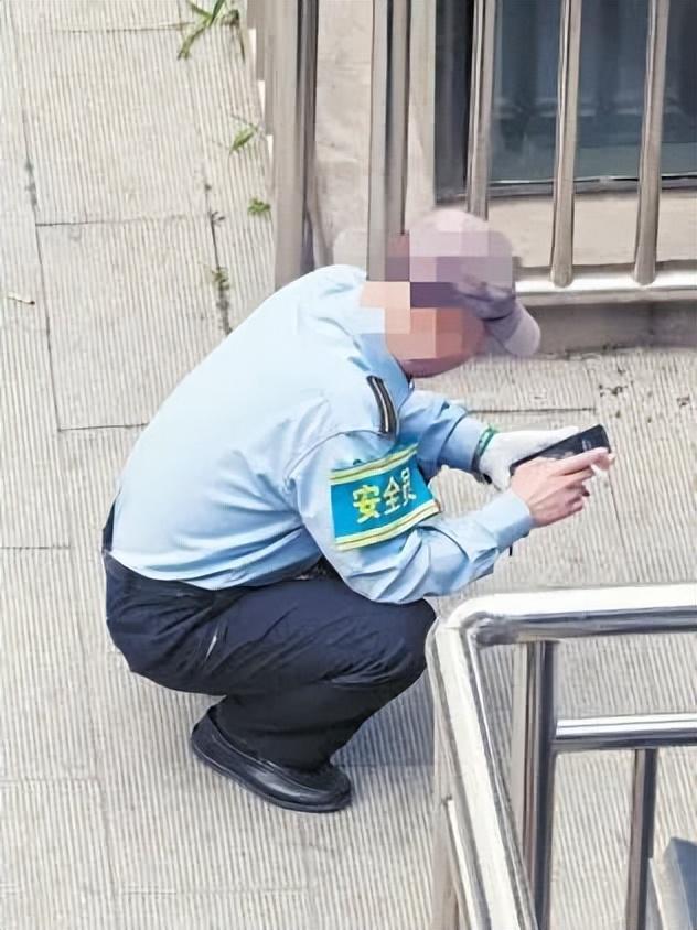 北京西站南广场公交站4站台,一名工作人员在吸烟。