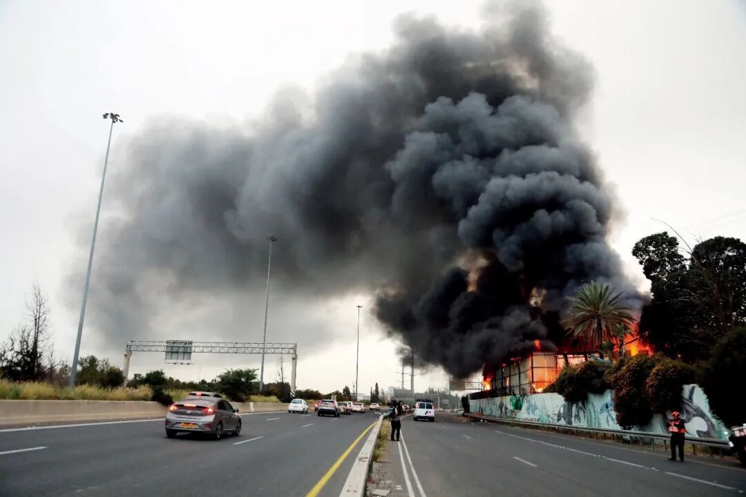 3月13日,在以色列中部城市霍隆,遭伊朗导弹袭击的一处地点冒出滚滚浓烟。图/新华