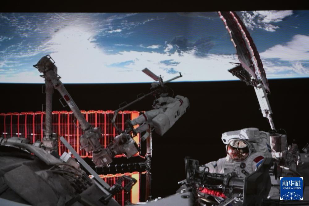 2025年12月9日18时45分，经过约8小时的出舱活动，神舟二十一号乘组航天员张陆、武飞、张洪章密切协同，圆满完成第一次出舱活动，完成了神舟二十号飞船返回舱舷窗巡检拍照等任务。这是12月9日在北京航天飞行控制中心屏幕上拍摄的神舟二十一号乘组航天员张陆与武飞（右）在舱外工作的画面。新华社记者 刘艺 摄