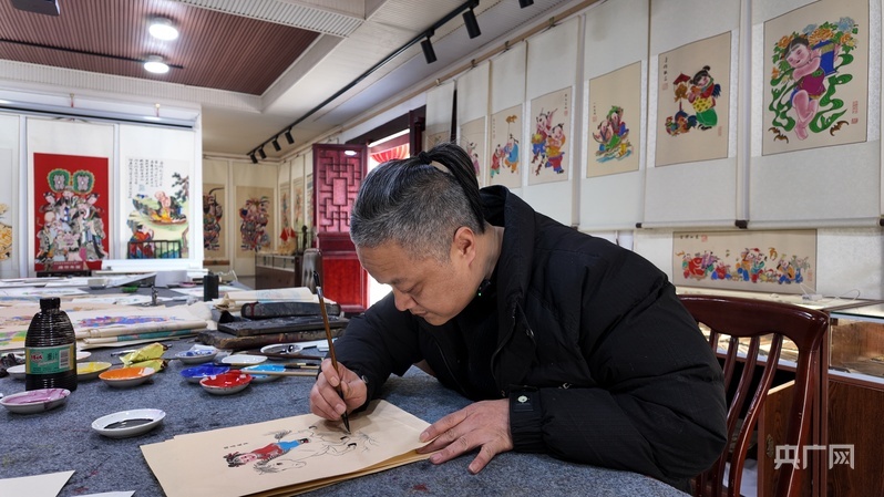 陈强正在为绵竹年画上色（央广网记者 昌思荣 摄）