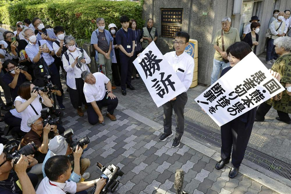 2023年9月27日,在大阪地方法院外,律师们在判决后展示“胜诉”横幅。法院当天责令中央政府、熊本县和窒素公司承认120多名原告为数十年前水俣汞中毒事件的患者,并向他们支付赔偿金。