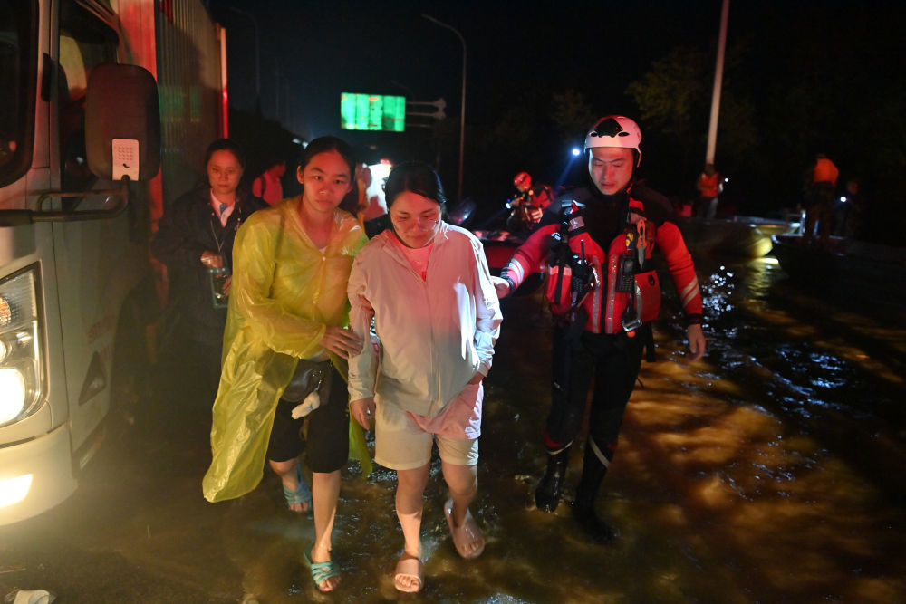 ↑ 7月7日,救援人员在广西贵港市西江教育园区连夜冒雨转移群众。