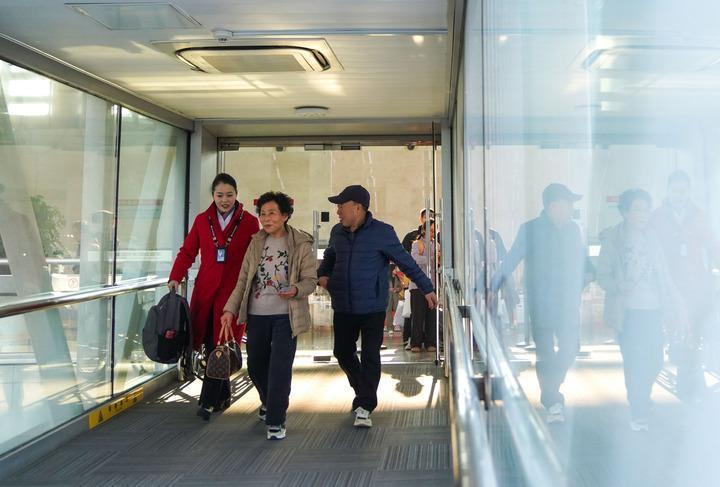 长春龙嘉国际机场，中国南方航空公司工作人员引导“反向春运”的旅客登机。新华社记者 许畅 摄