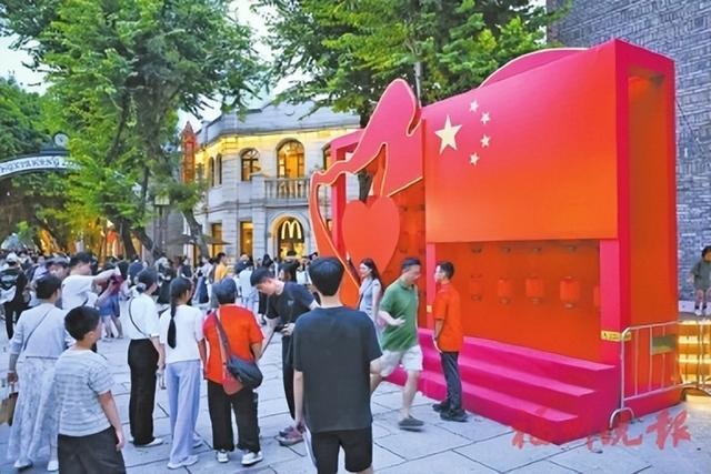 游客在上下杭金银里广场与五星红旗合影。