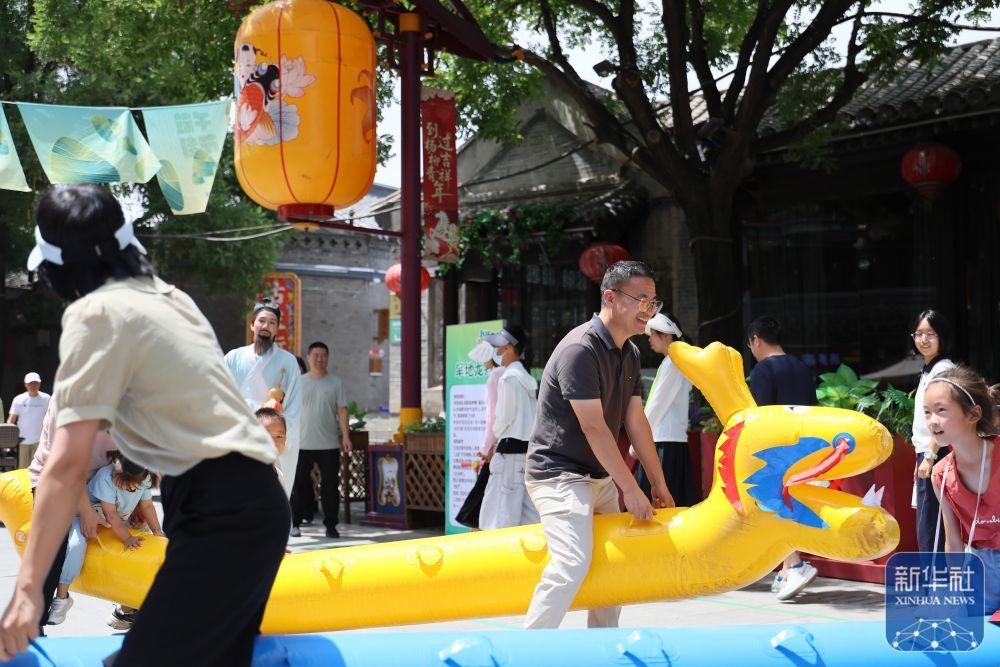 ↑ 6月21日,游客在天津市西青区杨柳青古镇体验旱地龙舟。新华社记者 李然 摄
