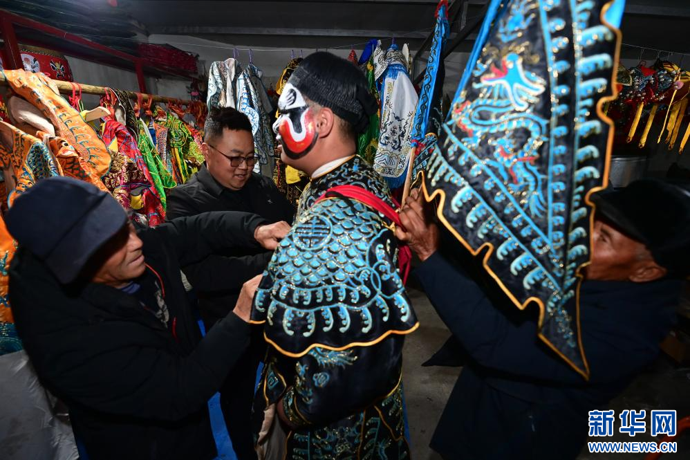 3月2日凌晨,陇县黄花峪村村民为社火队队员穿戴演出服饰。新华社记者 邹竞一 摄