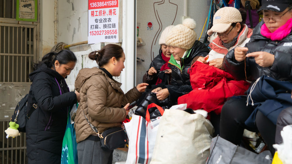 周边居民把衣服拿到“零工微站”织补。新华社记者 熊翔鹤 摄