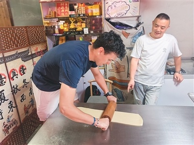 浙江宁海,法国友人在前童古镇一家海苔饼店体验制作海苔饼。汪静宜摄