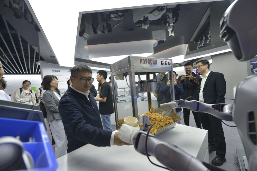 2025年10月29日，在广东深圳越疆科技有限公司，机器人为记者装爆米花。新华社记者 刘力航 摄