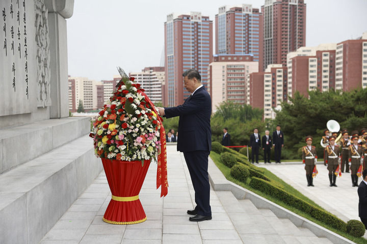 当地时间6月9日上午,正在朝鲜进行国事访问的中共中央总书记、国家主席习近平和夫人彭丽媛参谒中朝友谊塔。朝鲜劳动党总书记、国务委员长金正恩和夫人李雪主陪同。这是习近平整理花篮缎带。新华社记者 丁海涛 摄
