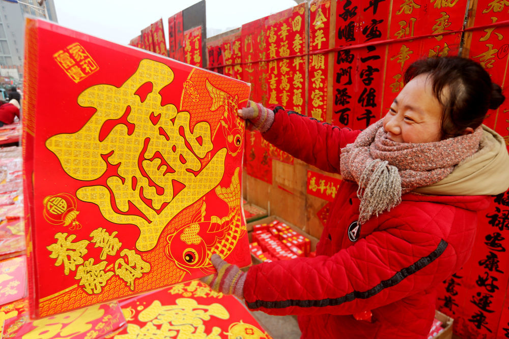 ↑ 2月15日，市民在江苏省连云港市连云区一年货市场选购新春饰品。新华社发（王春 摄）