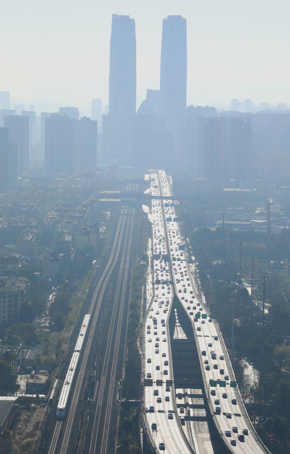 ↑ 1月25日,动车组列车穿行于云南昆明城区。新华社发(郑益 摄)