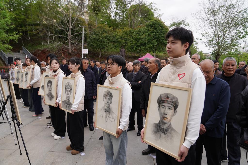 在瑞金革命烈士陵园，来自各高校的学生志愿者向烈士家属赠送烈士画像（4月1日摄）。新华社记者 周密 摄