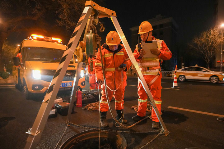 2月4日0时27分许，京能集团北京热力输配分公司管网二所运行五班线长韩朝阳（右）和班组成员在下井作业前，使用仪器检测井下的各项气体安全指标。新华每日电讯记者鞠焕宗 摄