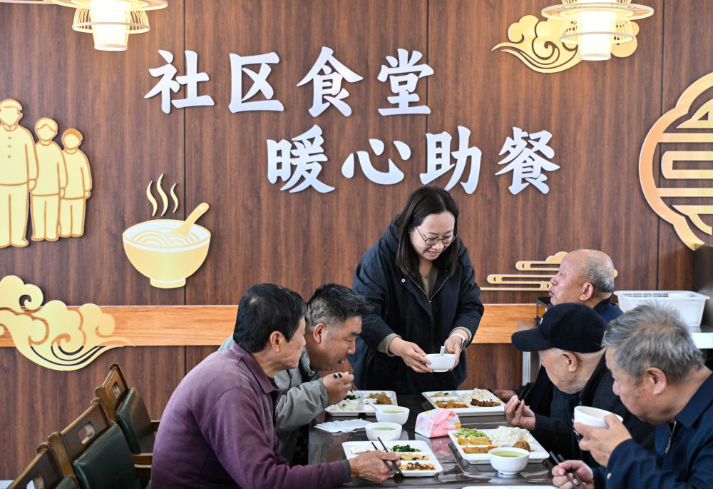 4月29日,在江苏省扬州市江都区邵伯镇甘棠社区幸福邻里食堂,社区工作人员给老年居民端汤。新华社记者 季春鹏 摄
