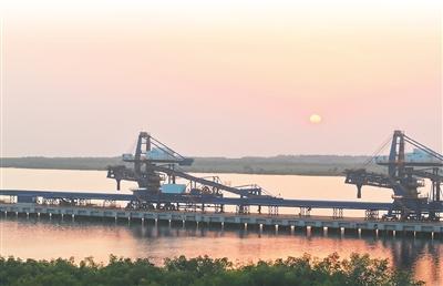 几内亚西芒杜马瑞巴亚港口，落日余晖下，装船机在水面映出剪影。闫碧泓摄