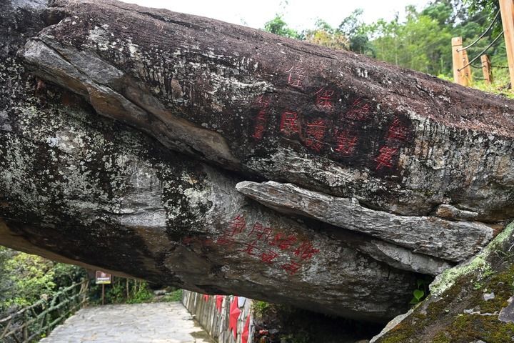这是2026年10月5日在广西桂林市龙胜各族自治县周家村白面瑶寨拍摄的“红军岩”上的标语。这块被称作“红军岩”的石头上,红色的字迹——“红军绝对保护傜民”,历经九十余载风雨,依然熠熠生辉。新华社记者 曹祎铭 摄