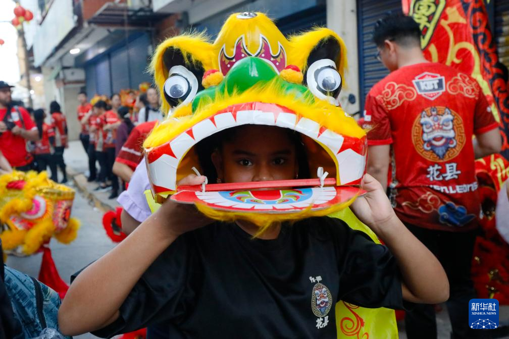 2月17日,在巴拿马首都巴拿马城唐人街,一名儿童戴上狮头道具参加春节庆祝活动。新华社发(丹尼尔·冈萨雷斯摄)