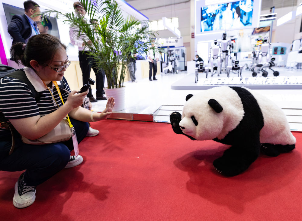 6月23日，参观者在链博会数智科技链展区与一台机器"熊猫"互动。新华社记者张誉东摄