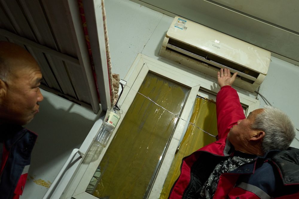 工友们回到宿舍打开空调取暖。