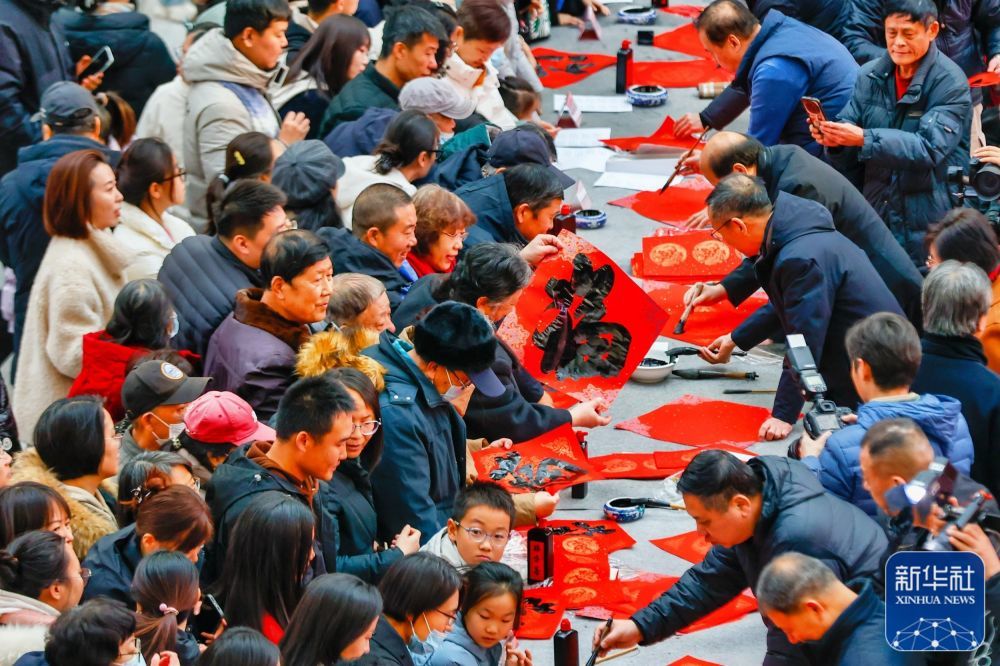↑ 1月22日，文艺工作者在天津市滨海文化中心为市民现场书写春联和“福”字。新华社发（杜鹏辉摄）