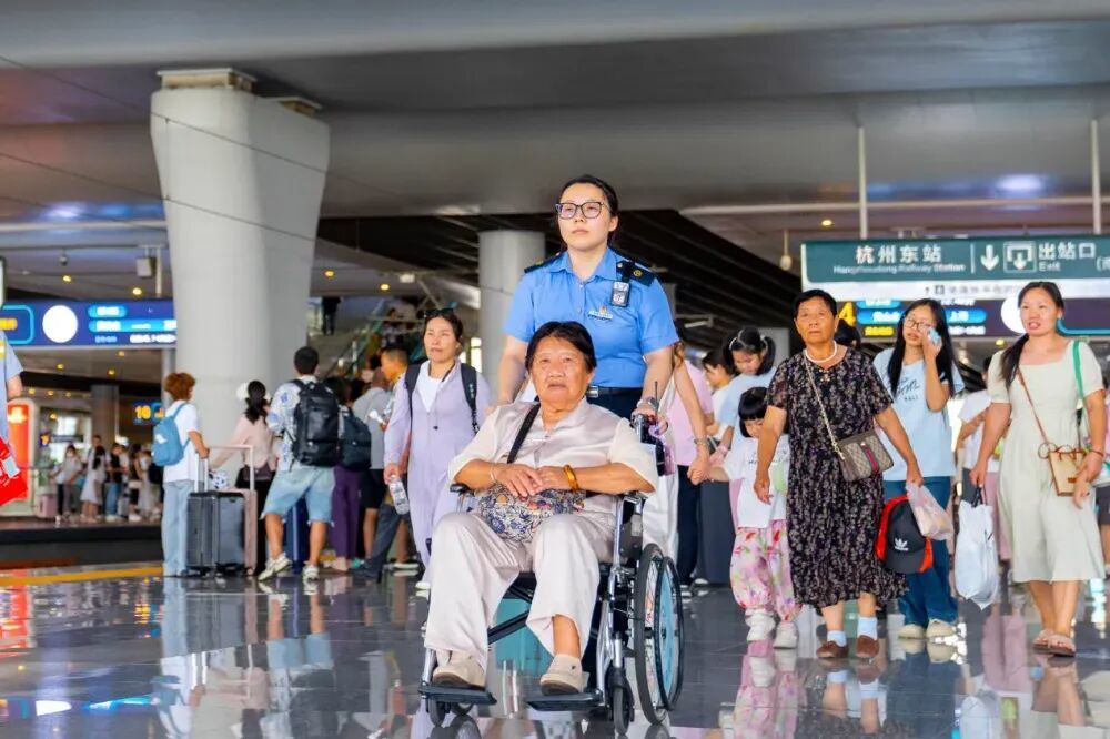 (杭州东站“之江心驿”雷锋服务站工作人员服务重点旅客。祝泰郎 摄)
