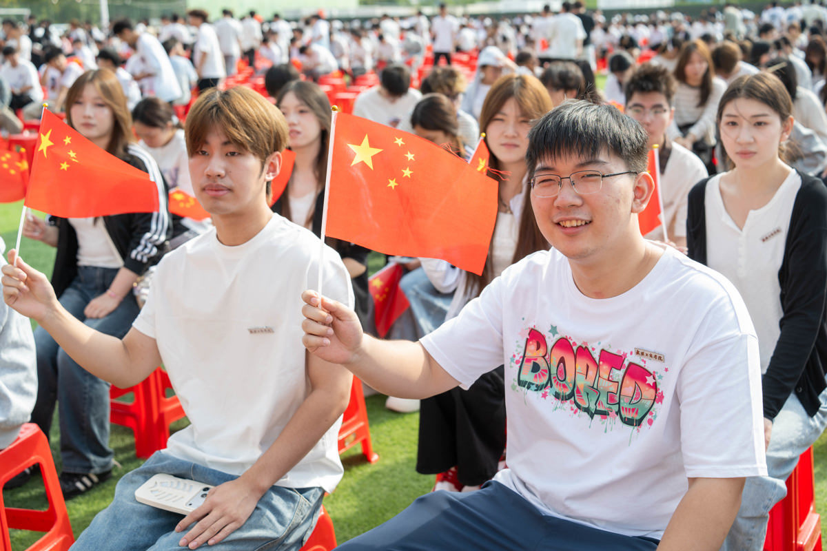 图为新生们挥舞手中小国旗 摄影:曹子涵.jpg