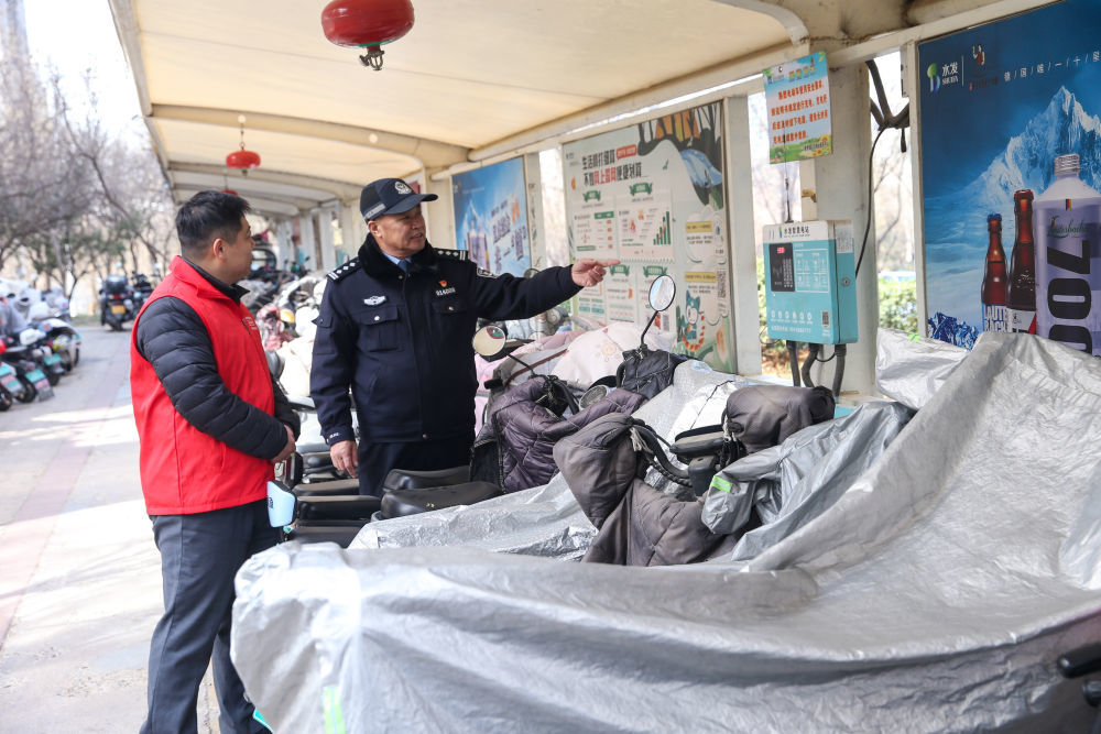↑ 2月16日，山东省济南市公安局市中分局十六里河派出所社区民警陈兴珍（右）与志愿者对小区电动车充电站进行安全检查。新华社发（郝鑫城摄）