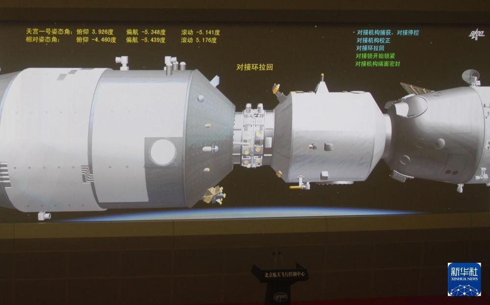 这是2012年6月24日拍摄的北京航天飞控中心大屏幕显示，在航天员的控制下，神舟九号与天宫一号的对接机构成功接触。新华社记者 王申 摄