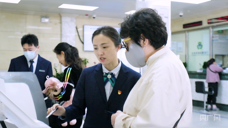 金慧琼协助老年客户办理业务（央广网记者 周思杨 摄）