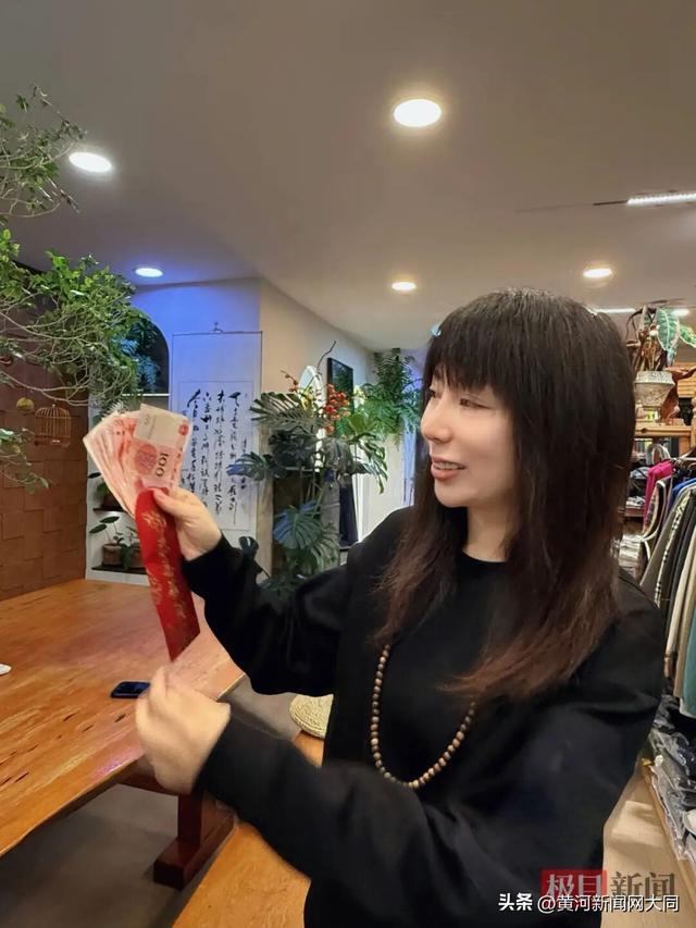 朱朱展示1000元红包，哭红了眼圈。极目新闻记者拍摄