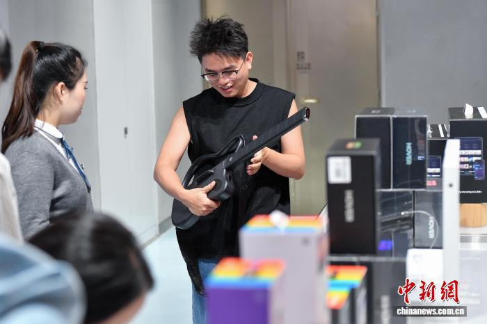 2025年11月1日，顾客在cdf海口国际免税城体验无弦吉他。 中新网记者 骆云飞 摄