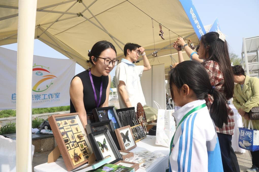 天津水上公园书市摊主在向读者介绍文创产品。（受访者供图）