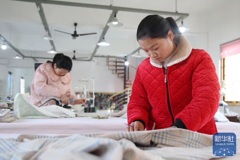 ↑ 1月5日，工人在湖北省十堰市郧阳区柳陂镇龙韵村一家布艺加工厂忙碌。新华社发（曹忠宏 摄）