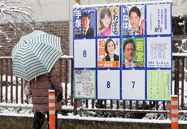 当地时间2月8日,日本国会众议院选举投票开始,选民经过候选人的宣传海报。 IC Photo