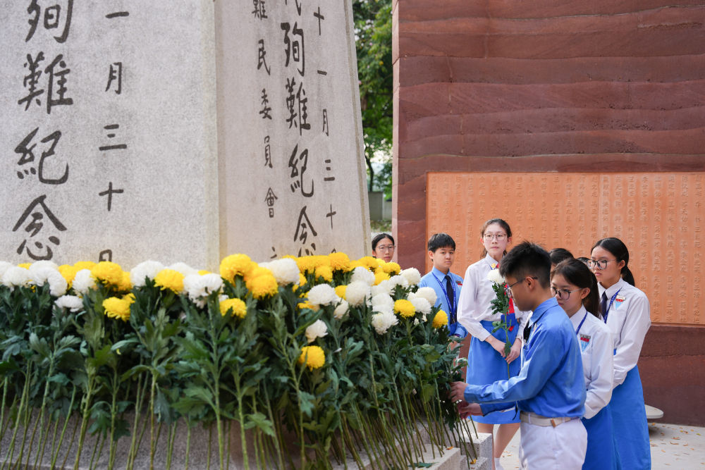 7月5日,在马来西亚首都吉隆坡的南侨机工纪念公园,学生们在南侨机工公祭典礼上献花。新华社记者 陈泽国 摄