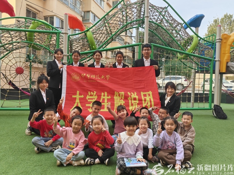 伊犁师范大学大学生解说团在幼儿园与孩子们分享红色故事后，合影留念。伊犁师范大学供图
