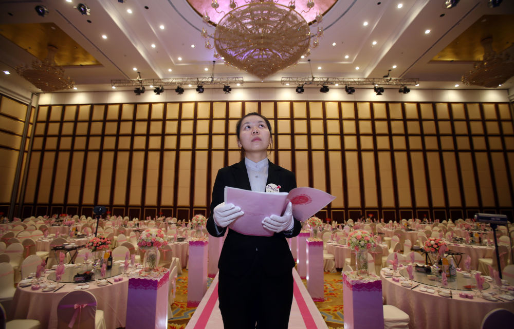 2014年4月19日上午，在湖南长沙的一场婚礼仪式前，婚礼策划师刘宁波拿着图纸核对每一处细节。新华社记者 李尕 摄