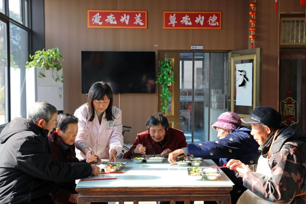 护理人员在江苏省海安高新区隆政街道德兴村亲上亲养老小院照顾老人用餐（2025年12月28日摄）。新华社发（顾彬斌 摄）