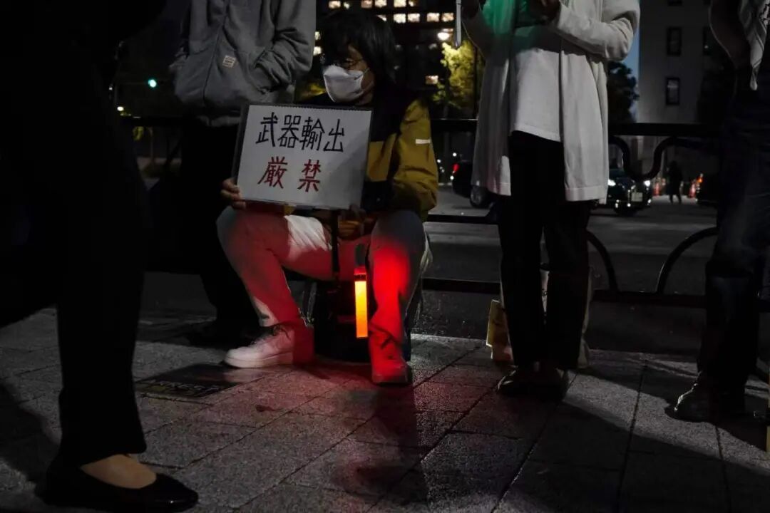 4月16日,日本东京的首相官邸前,抗议者手持标语参加集会,抗议高市政府企图解禁杀伤性武器出口。(图源:新华社)