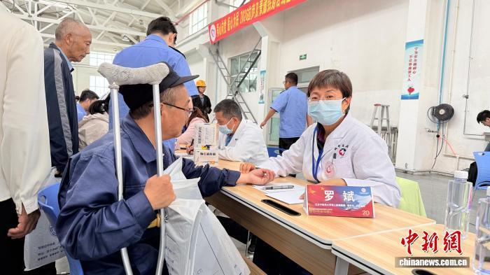 7月10日,参加2026年“同心·共铸中国心”西藏拉萨、青藏铁路沿线公益活动的部分医疗专家来到格尔木机务段,开展医疗公益活动。图为来自北京的医疗专家罗斌在为铁路一线职工和沿线群众义诊。受访者供图