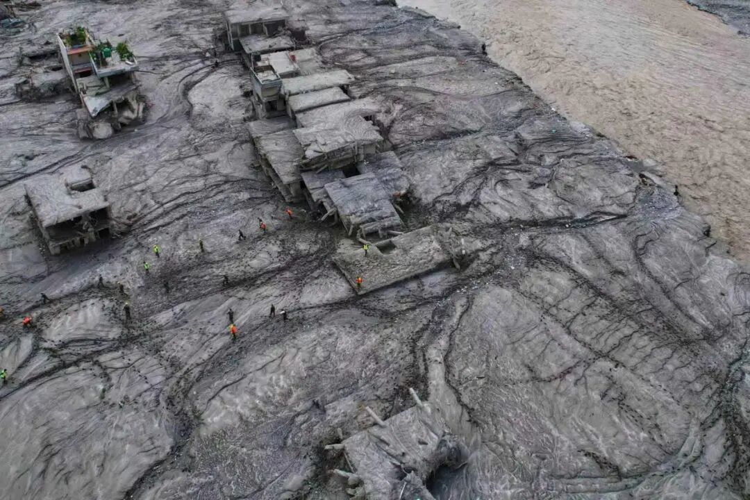 8月29日，尼泊尔努瓦科特县，救援人员在受灾区域进行勘查，周边建筑严重损毁。（图源：美联社）